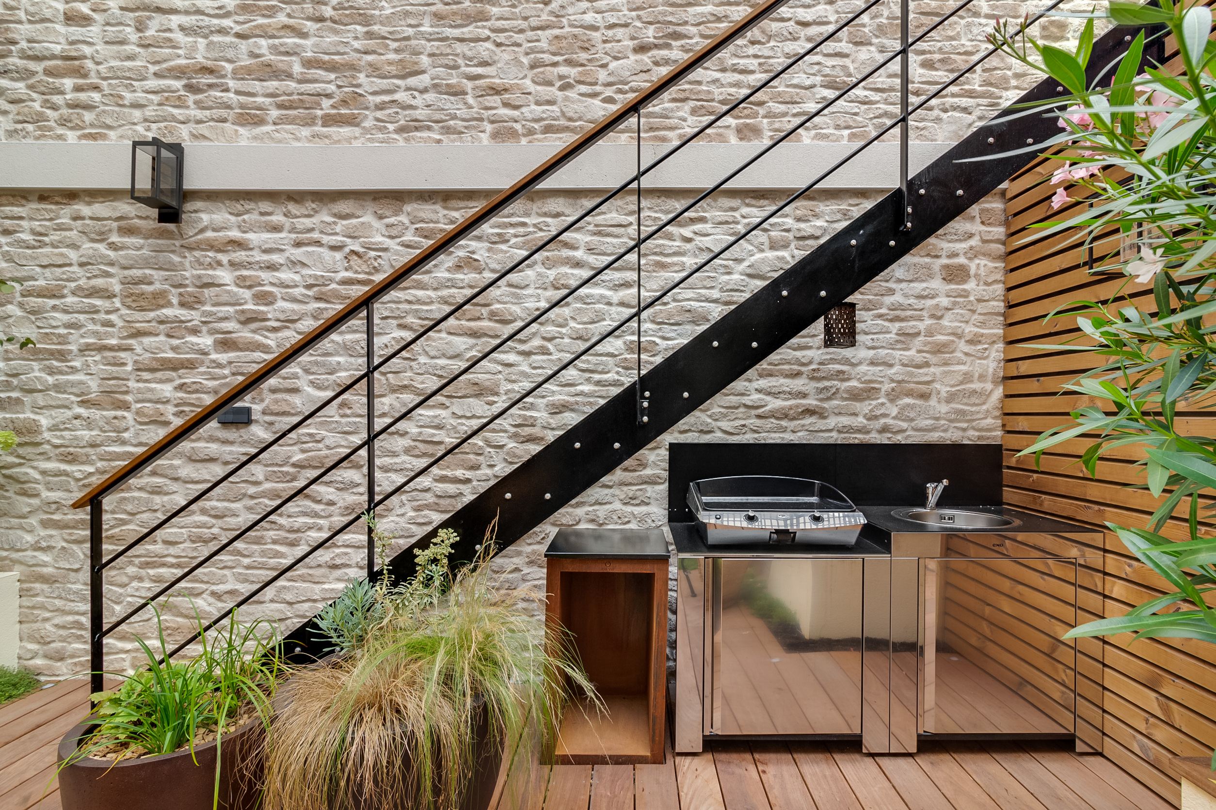Petit espace extérieur revêtit de parement Causse ton naturel et escalier en acier.