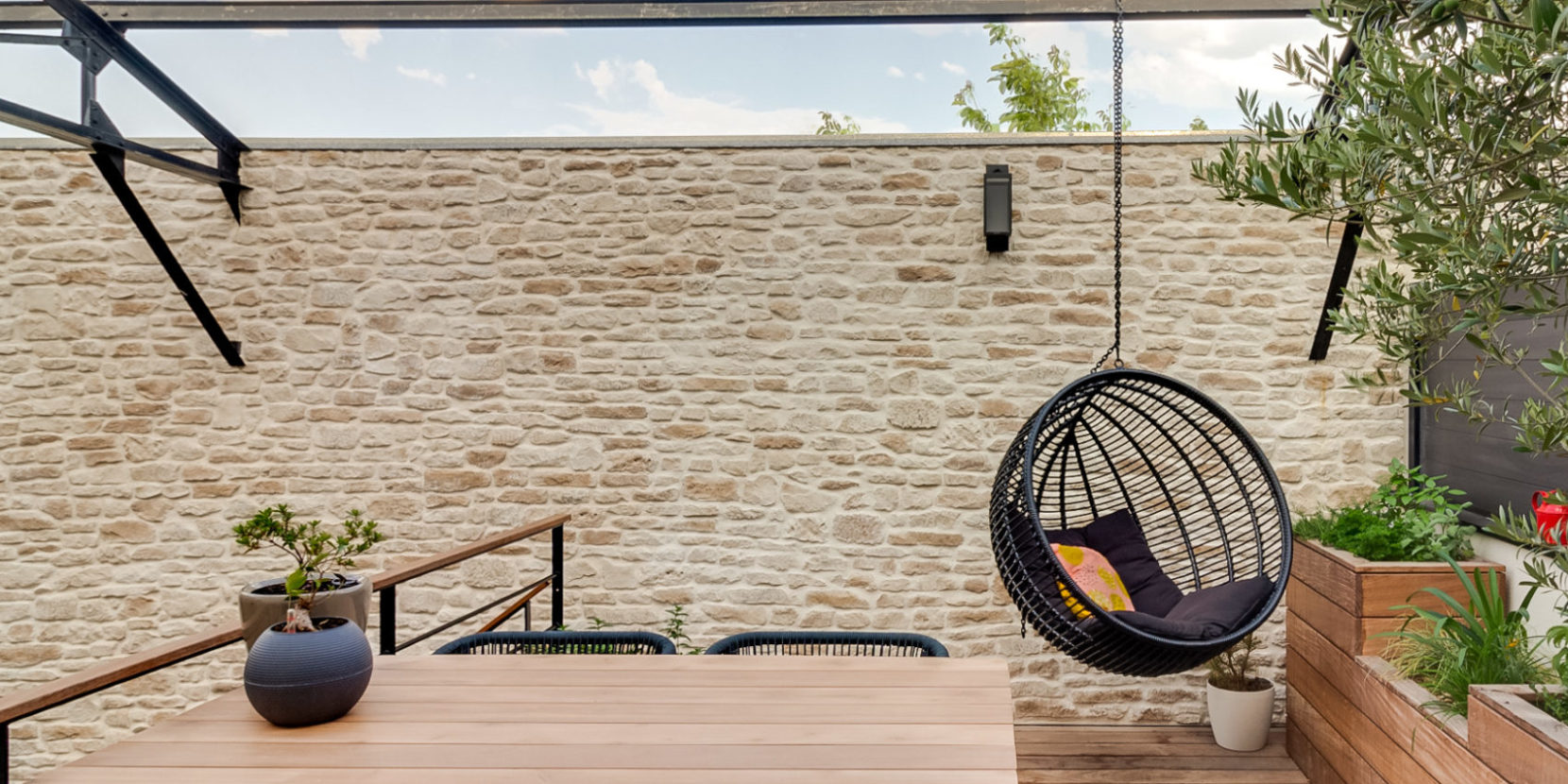 Terrasse extérieur avec jardinière en bois et muret en pierre de parement Causse de chez ORSOL