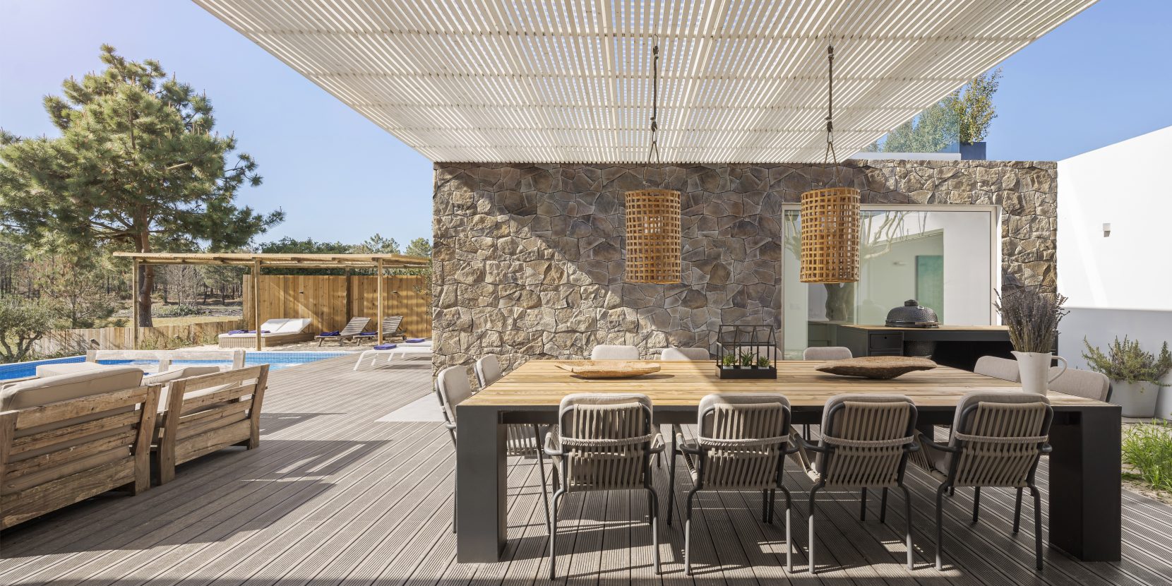 villa moderne en Espagne avec terrasse moderne avec piscine, grande table pour accueillir les invités, sol en bois, parement sur le mur Incerto ORSOL
