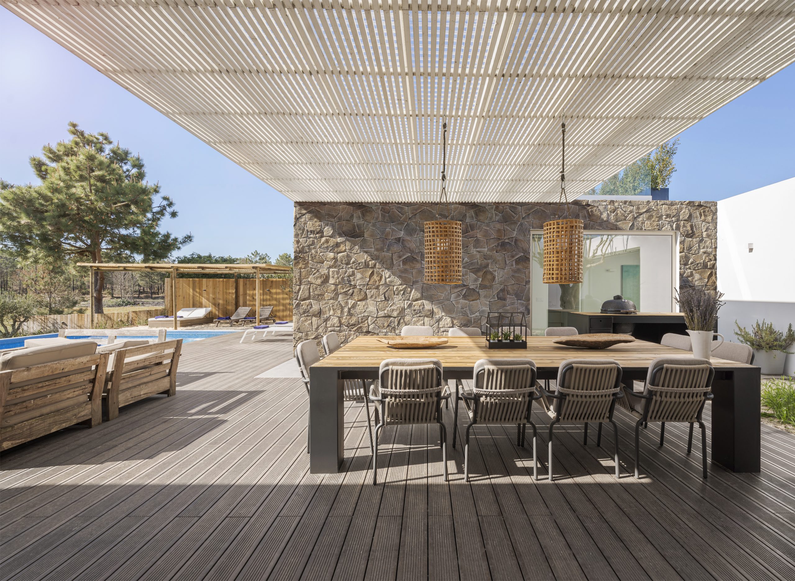 villa moderne en Espagne avec terrasse moderne avec piscine, grande table pour accueillir les invités, sol en bois, parement sur le mur Incerto ORSOL