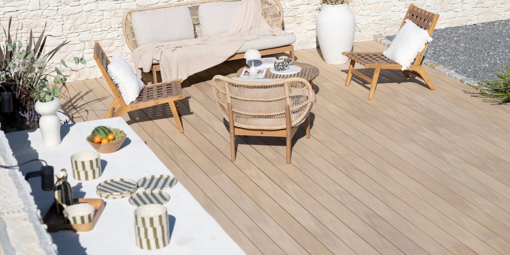 Terrasse et cuisine d'été décorée avec un mur en parement en pierre Tertus