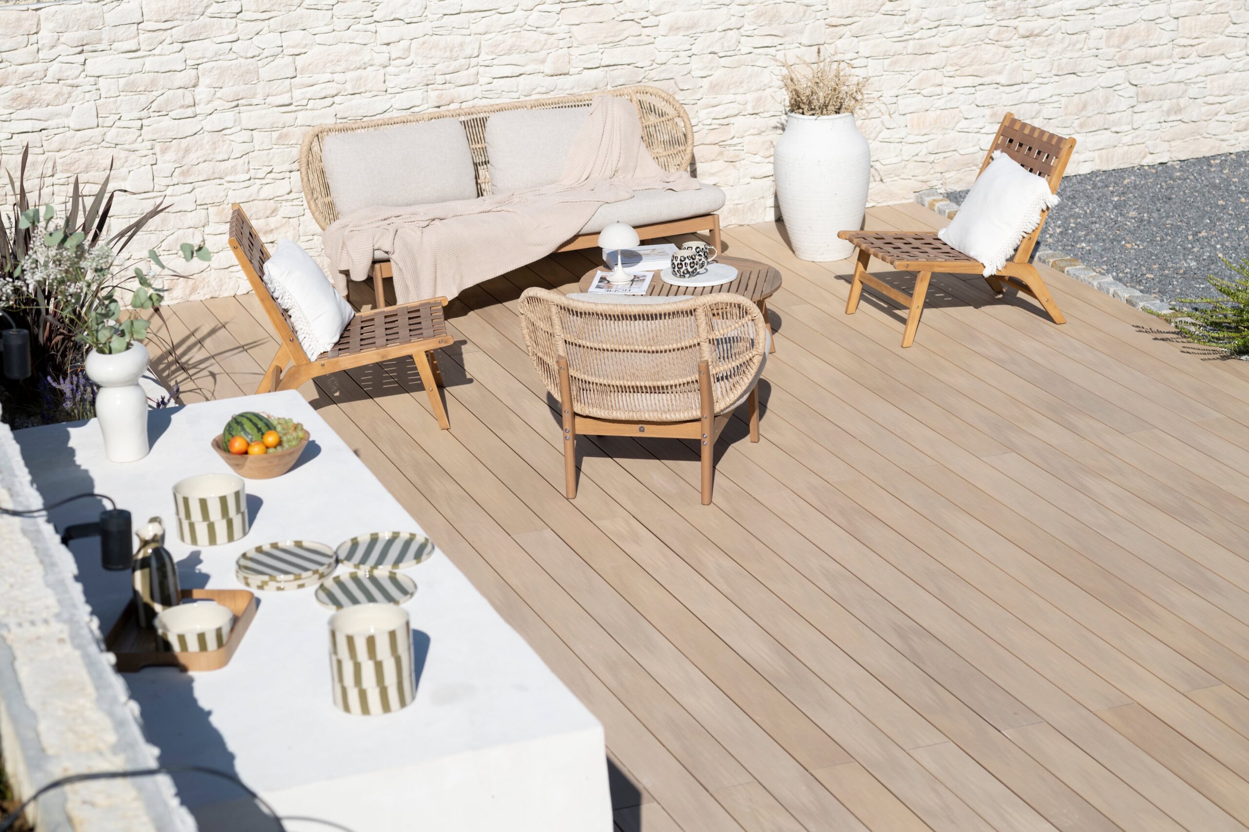 Terrasse et cuisine d'été décorée avec un mur en parement en pierre Tertus